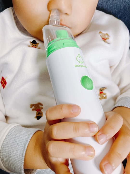 鼻水吸引器を自分で操作する3歳児